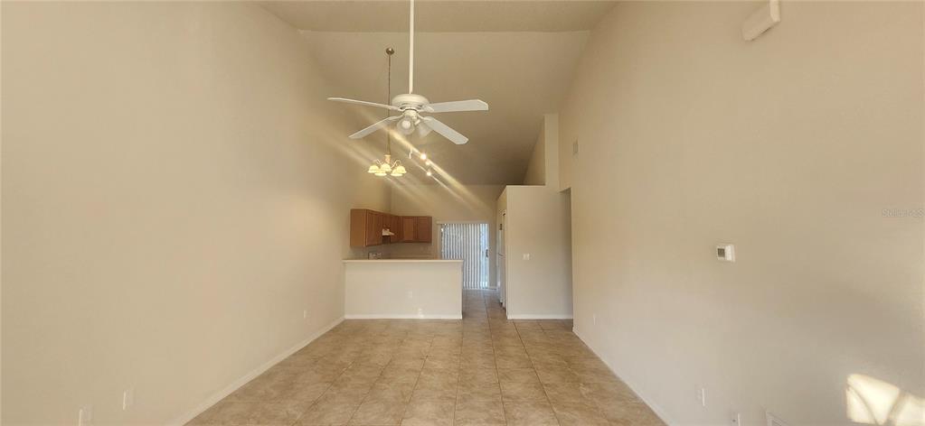 7411 Canterbury Street Spring Hill, FL 34606 - Photo 3 of 28 a view of a hallway with wooden floor and a chandelier