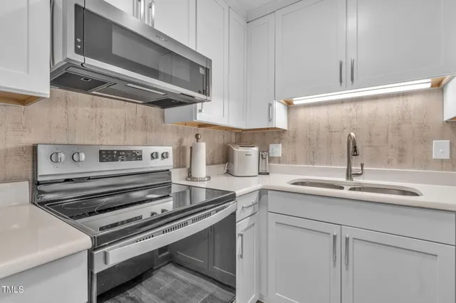 a kitchen with a stove cabinets and a sink