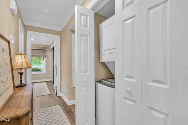 a view of a hallway with wooden floor and a bathroom