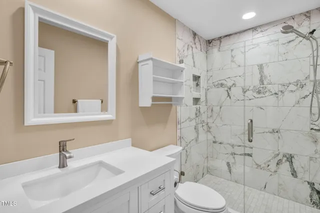 a bathroom with a sink toilet vanity and shower