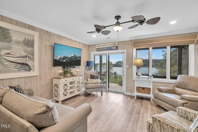 a living room with furniture large window and wooden floor