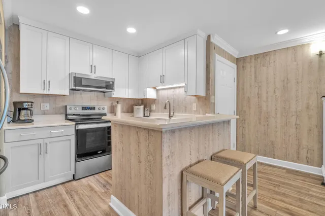 a kitchen with stainless steel appliances granite countertop a white cabinets and a stove top oven