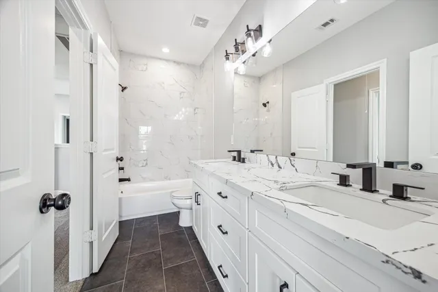 a spacious bathroom with double vanity sinks a large mirror and a shower