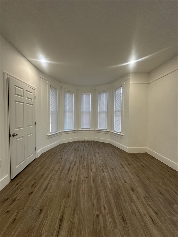 62 West 6th Street, Unit 1 Lowell, MA 01850 - Photo 5 of 11 wooden floor in an empty room with wooden floor
