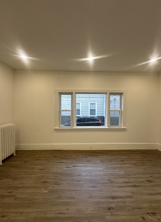 62 West 6th Street, Unit 1 Lowell, MA 01850 - Photo 8 of 11 a view of an empty room with wooden floor and a window