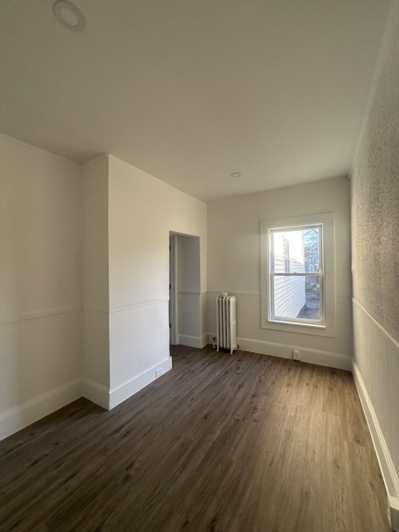 62 West 6th Street, Unit 1 Lowell, MA 01850 - Photo 9 of 11 an empty room with wooden floor and windows