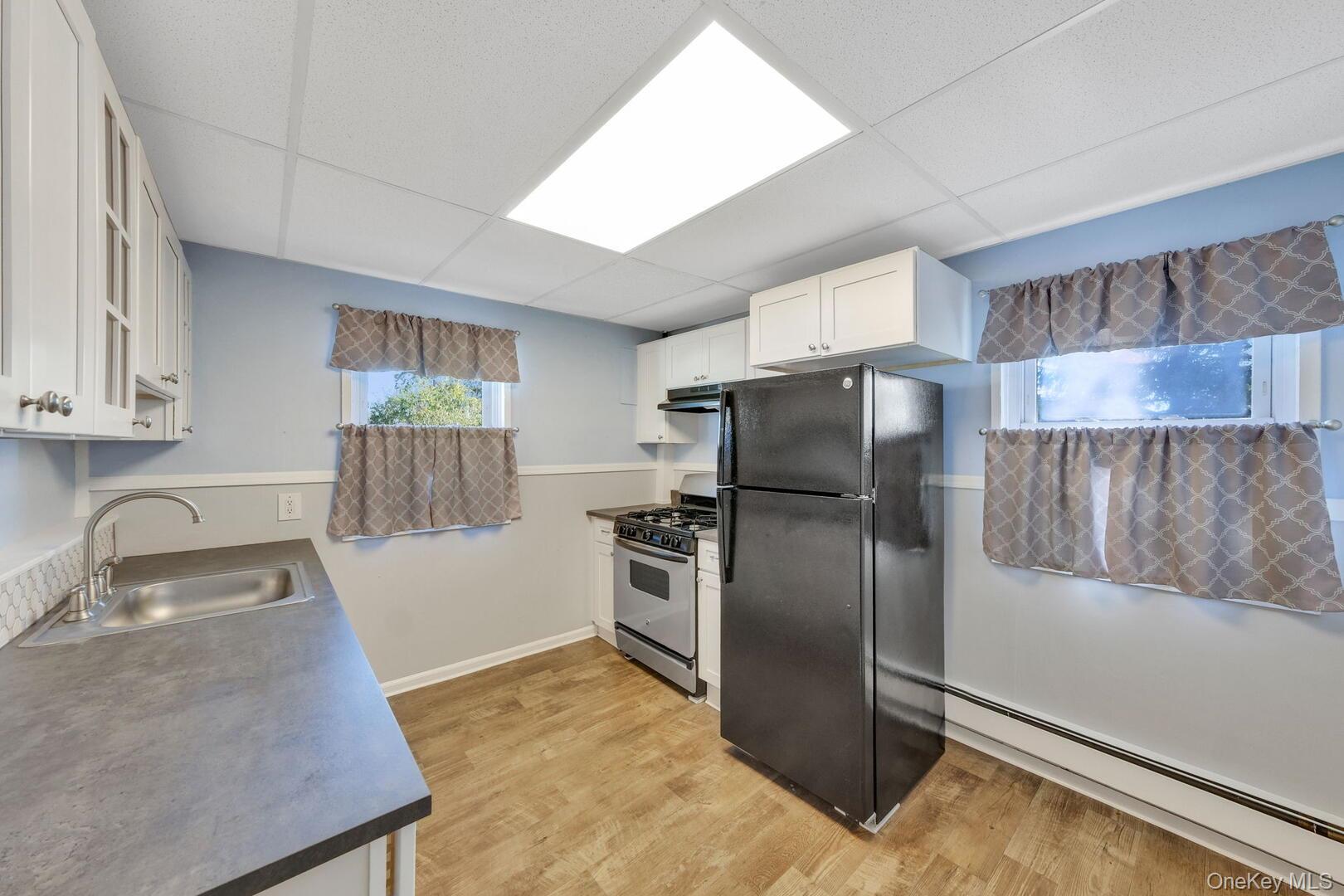 39 Chapman Place, Unit 2 Bay Shore, NY 11706 - Photo 5 of 17 a kitchen with granite countertop a refrigerator and a sink