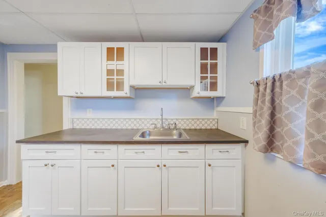 a kitchen with granite countertop white cabinets and white appliances