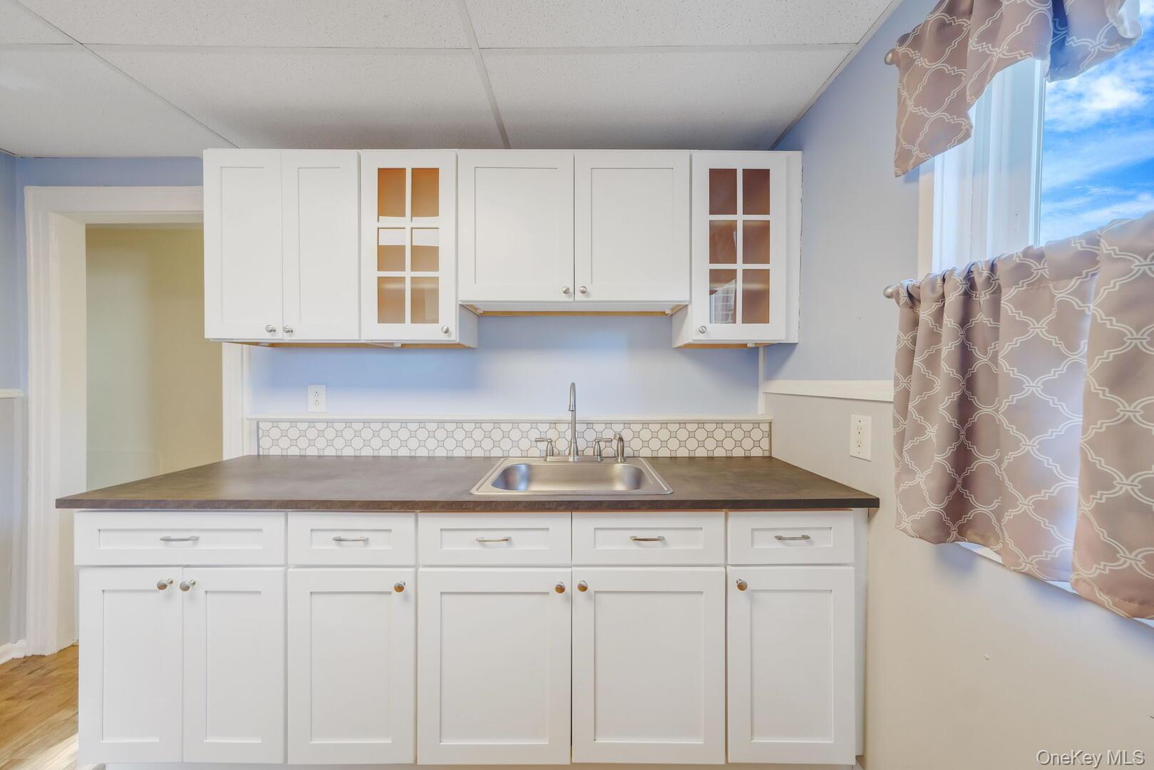 39 Chapman Place, Unit 2 Bay Shore, NY 11706 - Photo 6 of 17 a kitchen with granite countertop white cabinets and white appliances