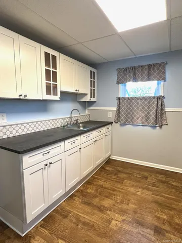 a kitchen with granite countertop a sink and cabinets