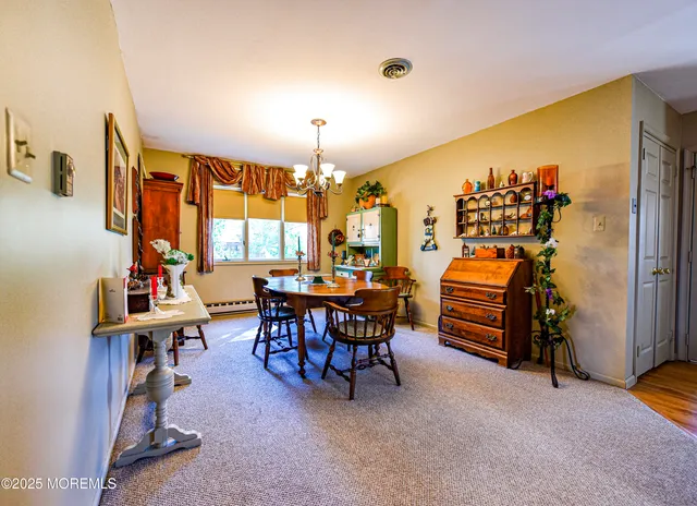 a living room with furniture a chandelier and a potted plant