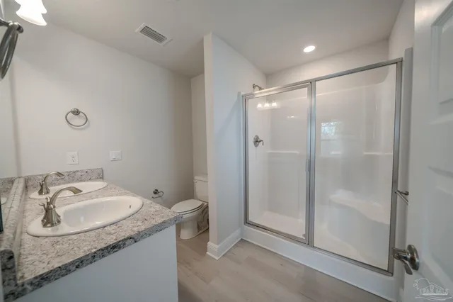 a bathroom with a granite countertop sink mirror and shower