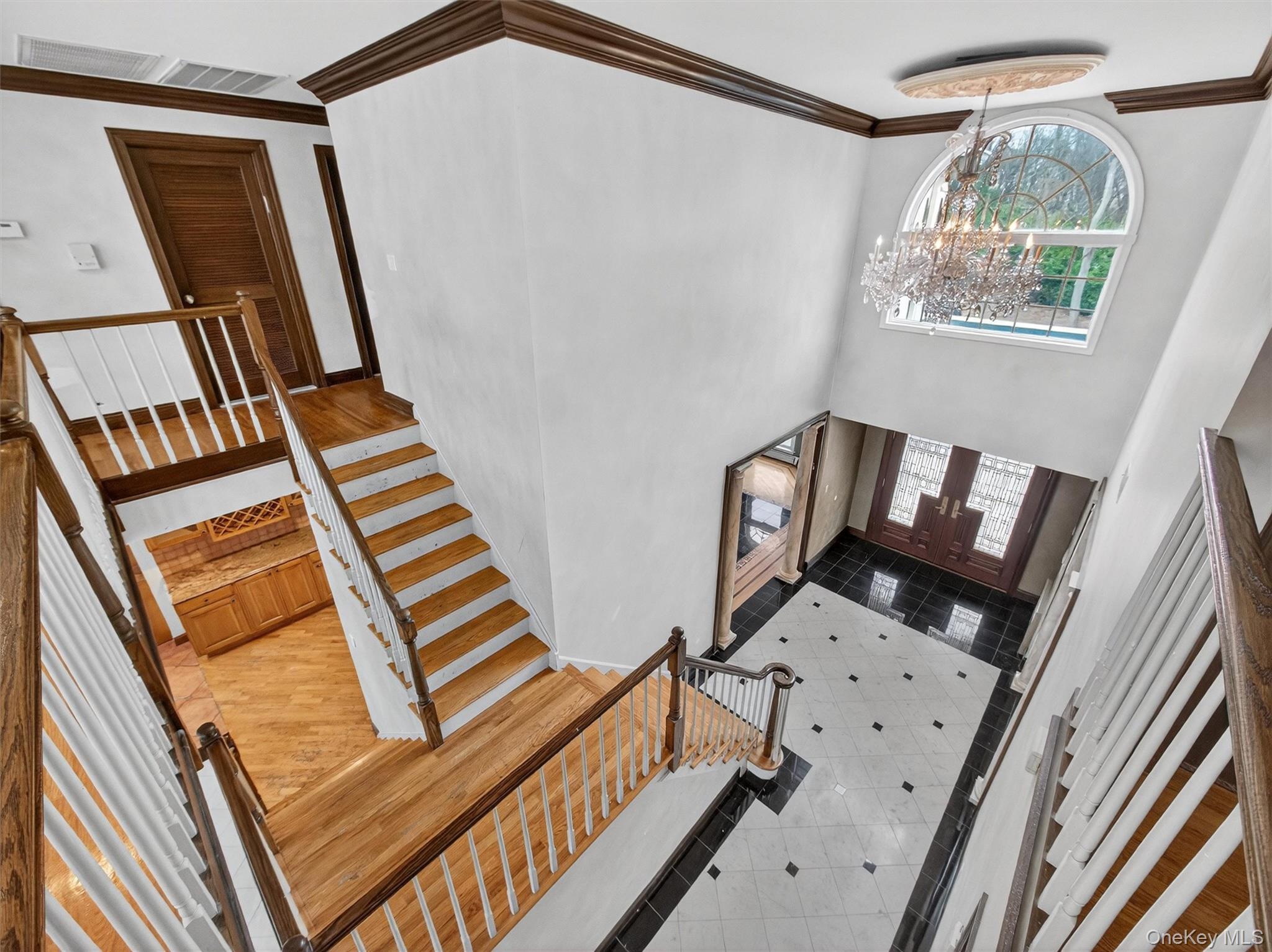 120 East Willow Tree Road Spring Valley, NY 10977 - Photo 30 of 49 Entryway with a chandelier, crown molding, stairway, light tile patterned floors, and a towering ceiling