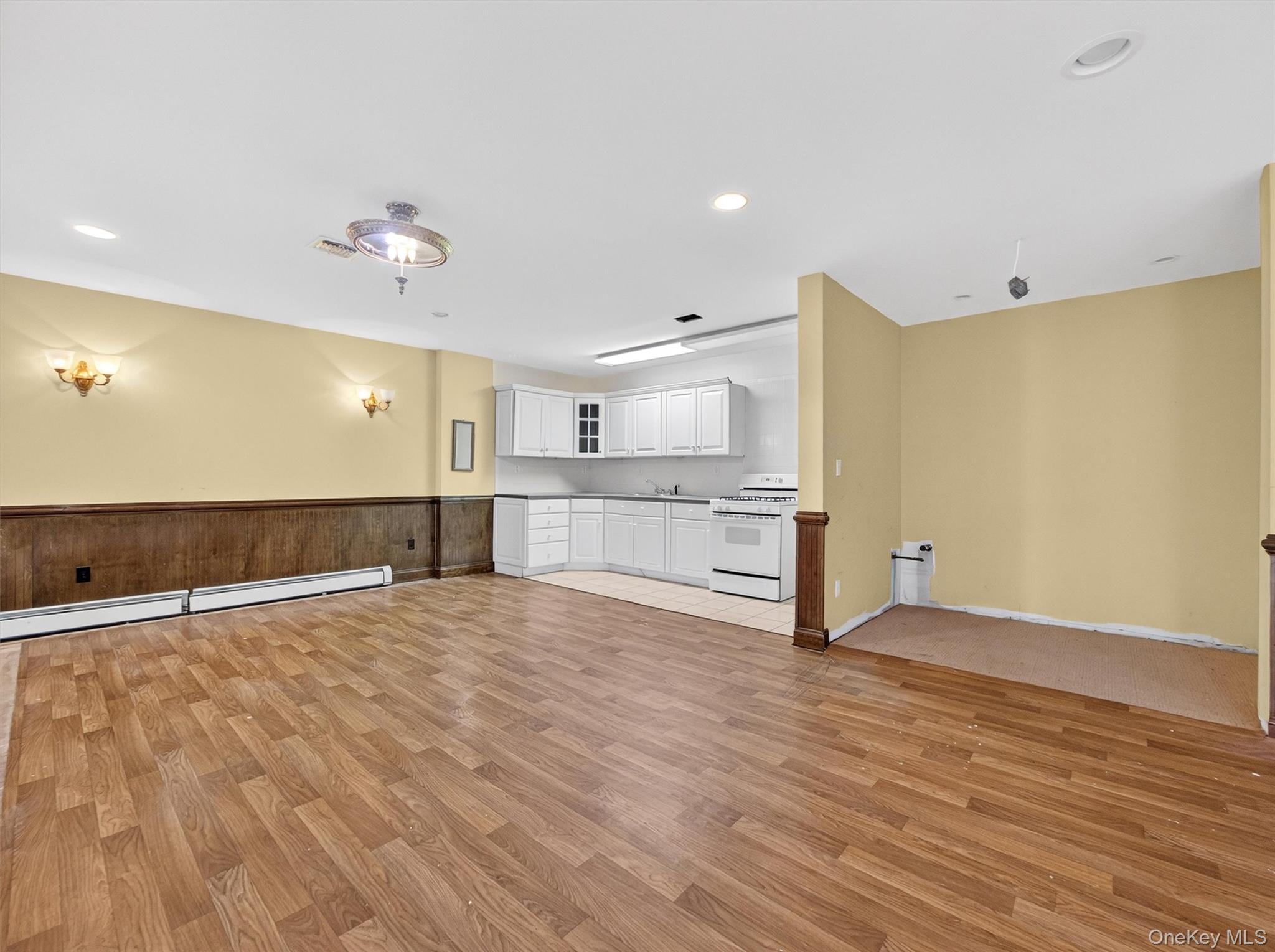 120 East Willow Tree Road Spring Valley, NY 10977 - Photo 49 of 49 Kitchen featuring open floor plan, white cabinets, white gas range, light wood-type flooring, and recessed lighting