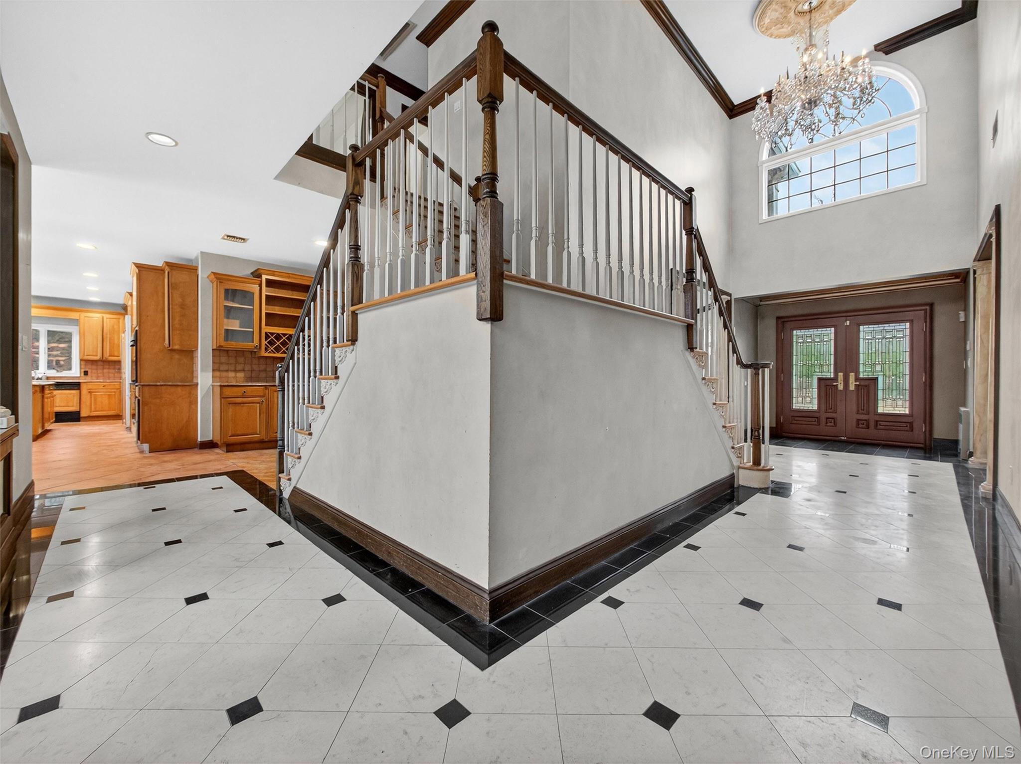 120 East Willow Tree Road Spring Valley, NY 10977 - Photo 4 of 49 Entryway featuring stairs, light tile patterned floors, a chandelier, ornamental molding, and inlaid floor details