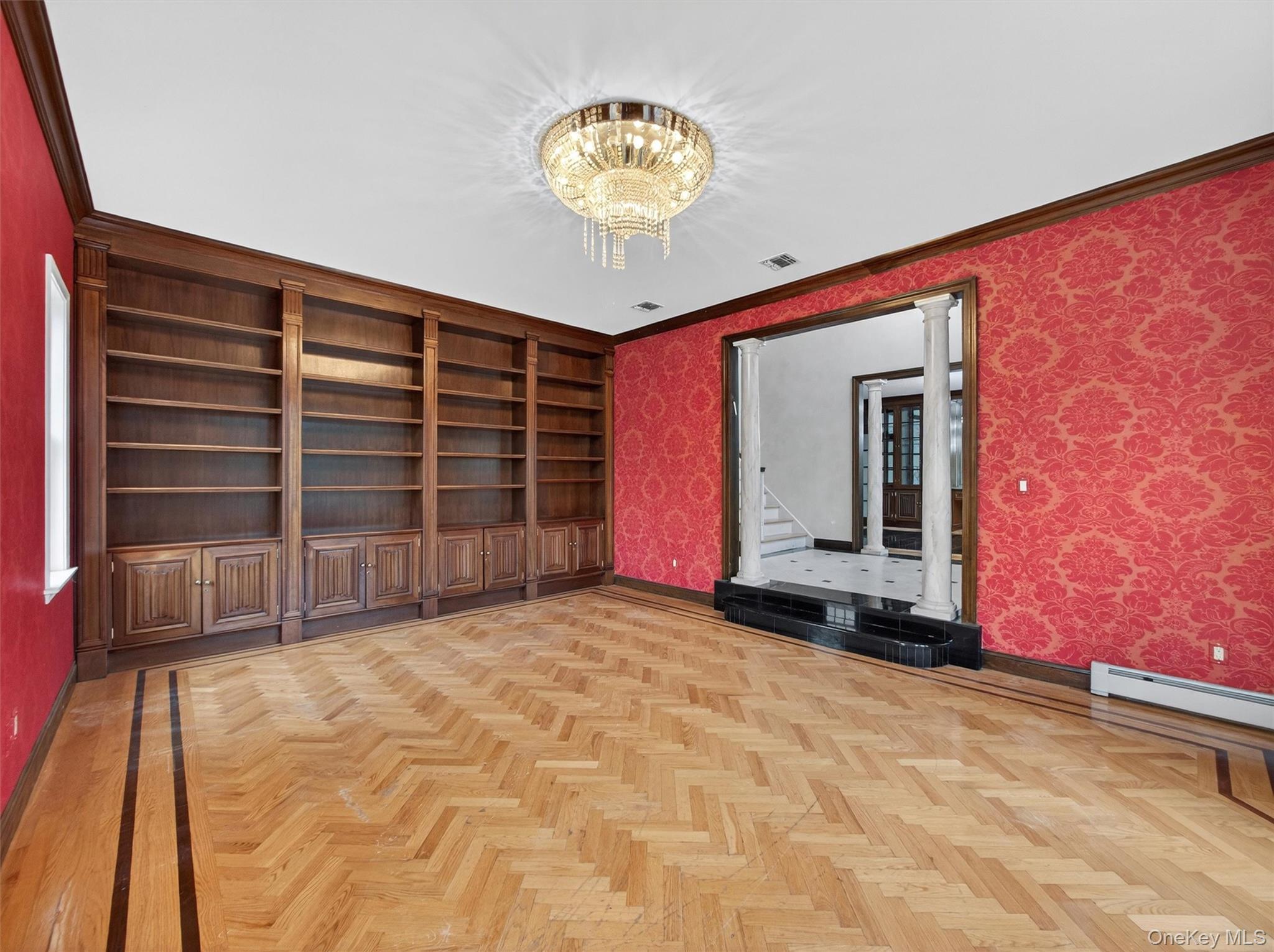 120 East Willow Tree Road Spring Valley, NY 10977 - Photo 7 of 49 Spare room featuring a chandelier, wallpapered walls, ornamental molding, and built in shelves