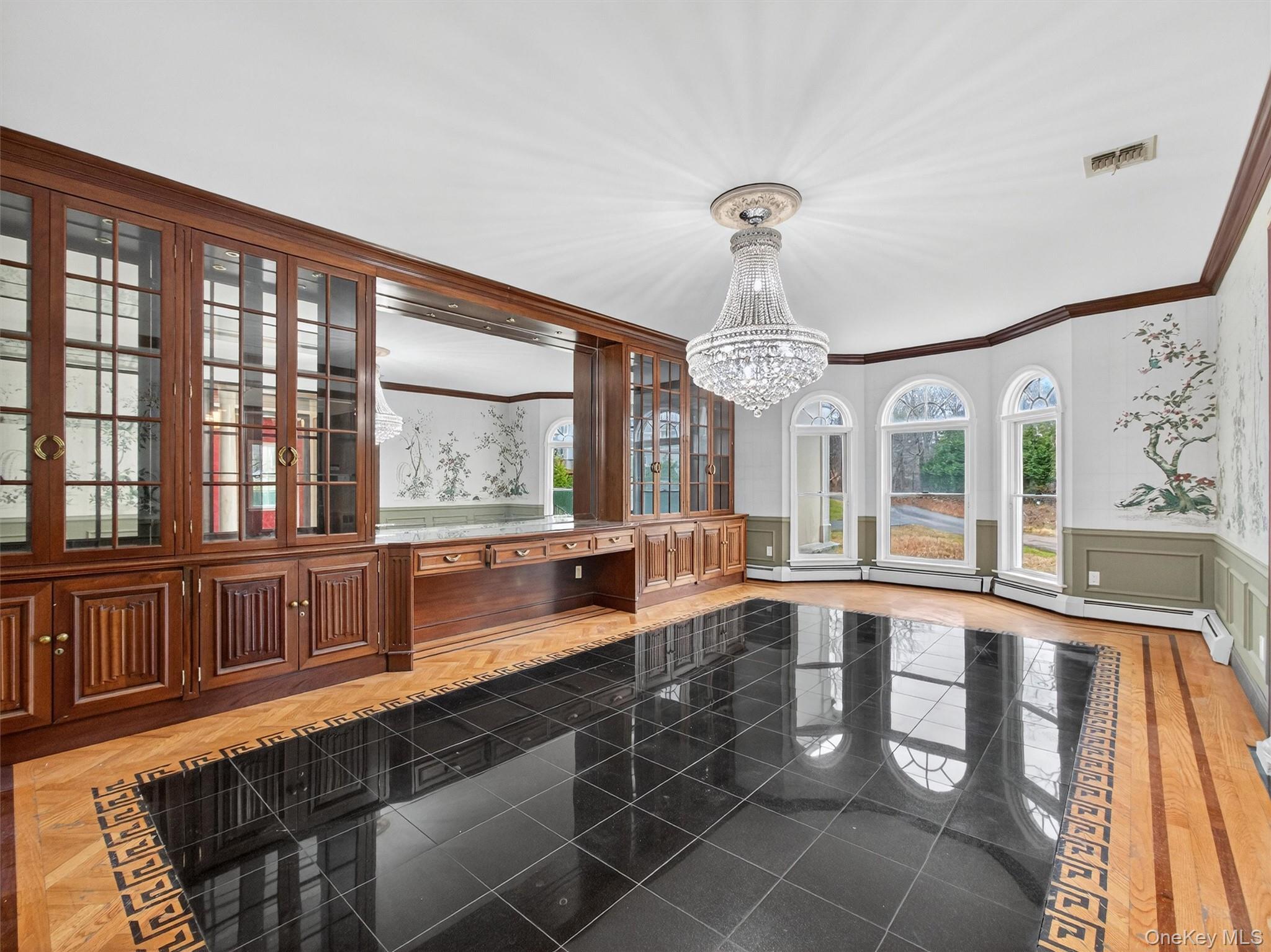120 East Willow Tree Road Spring Valley, NY 10977 - Photo 8 of 49 Unfurnished dining area with a wainscoted wall, a decorative wall, crown molding, a chandelier, and a baseboard heating unit