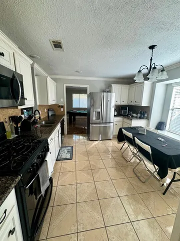 a kitchen with stainless steel appliances a stove sink cabinets and wooden floor