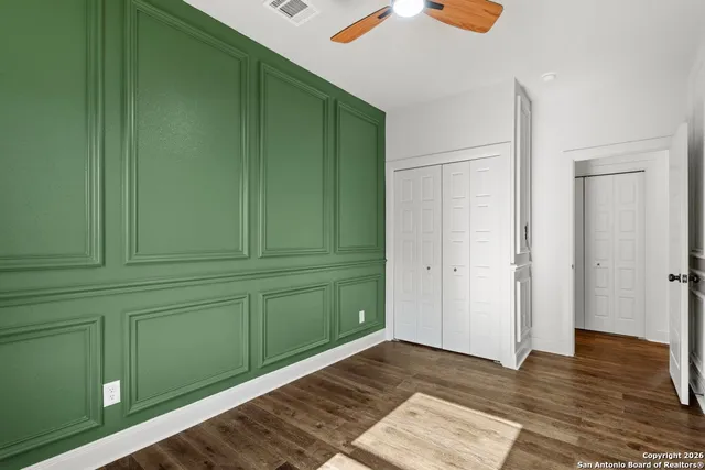 a view of a room that has wooden floor and cabinets