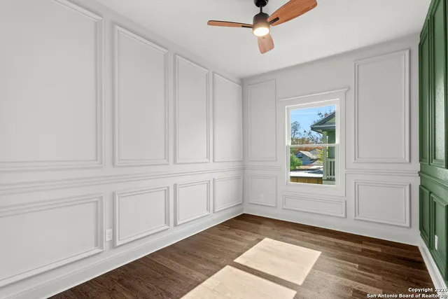 a view of an empty room with window and wooden floor
