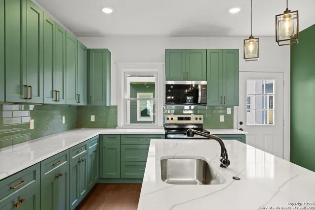 a kitchen with a sink a microwave and cabinets