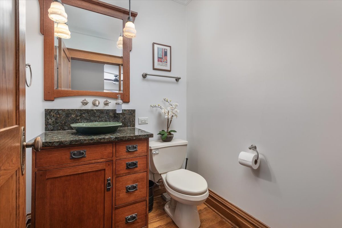 23 Columbia Street Naperville, IL 60540 - Photo 35 of 94 a bathroom with a granite countertop toilet a sink and a mirror
