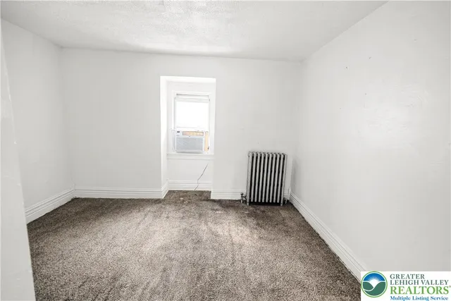a view of backyard with wooden fence and large trees