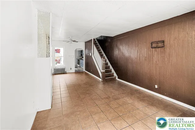 a view of an empty room with wooden floor and windows