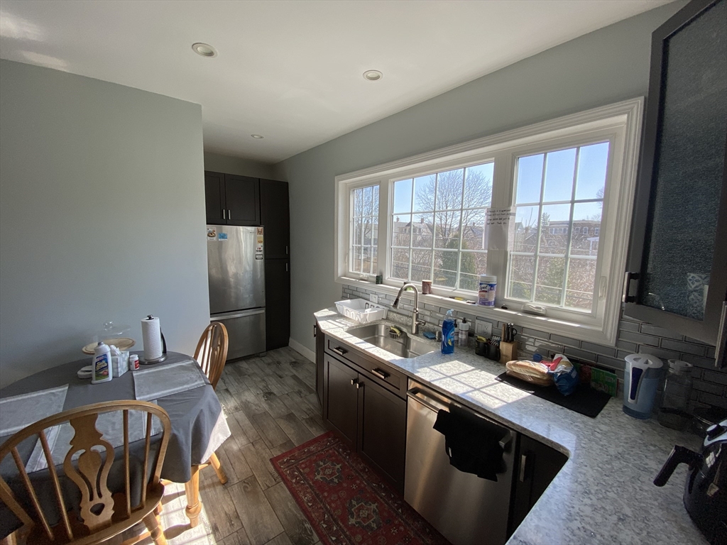 55 Cherry Street, Unit 55 Medford, MA 02155 - Photo 8 of 9 a kitchen with stainless steel appliances granite countertop a sink stove and refrigerator