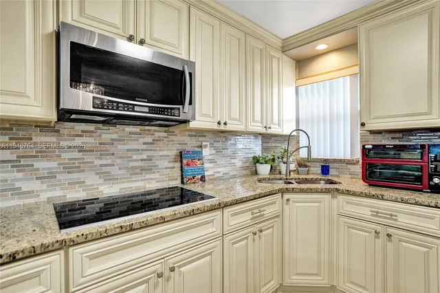 a kitchen with sink stainless steel appliances and cabinets