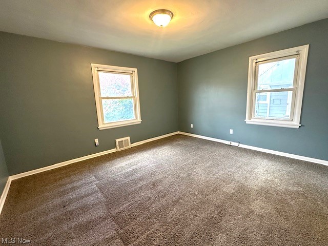 4230 Bluestone Road South Euclid, OH 44121 - Photo 9 of 35 Empty room featuring dark carpet and a healthy amount of sunlight