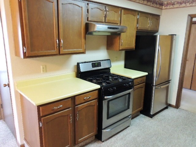5642 Spring Brook Road Rockford, IL 61114 - Photo 9 of 25 a kitchen with a stove and a refrigerator