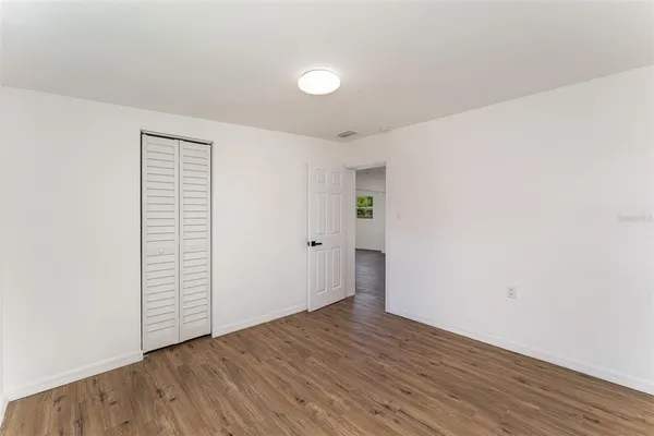 an empty room with wooden floor and white walls