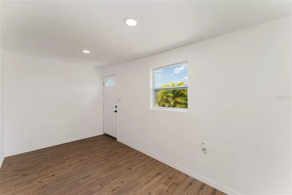 a view of an empty room with wooden floor