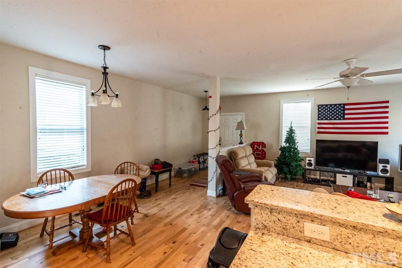 918 Chaney Road Raleigh, NC 27606 - Photo 3 of 4 a living room with furniture a fireplace and a flat screen tv