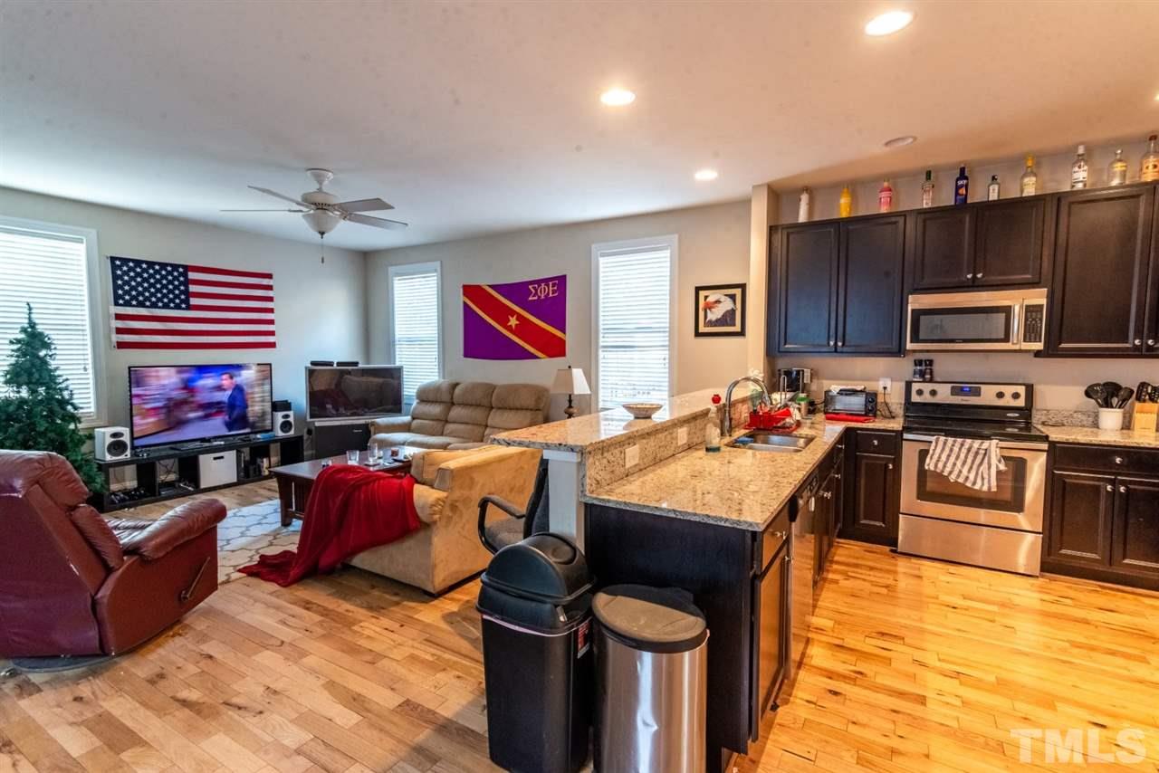 918 Chaney Road Raleigh, NC 27606 - Photo 4 of 4 a living room with stainless steel appliances furniture a fireplace and a open kitchen view