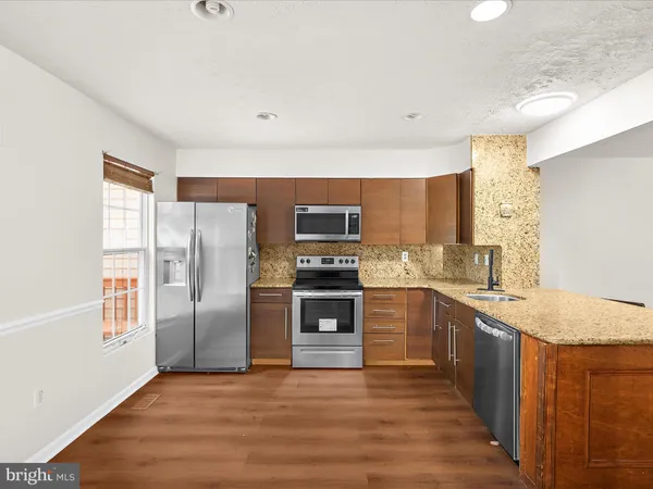 a kitchen with stainless steel appliances granite countertop a refrigerator and a stove top oven