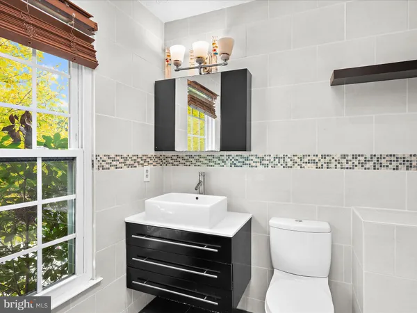 a bathroom with a sink a toilet and mirror