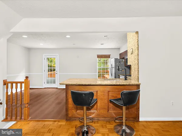 a kitchen with a dining table chairs and white cabinets