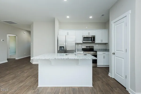 a kitchen with stainless steel appliances granite countertop a stove a sink and a refrigerator