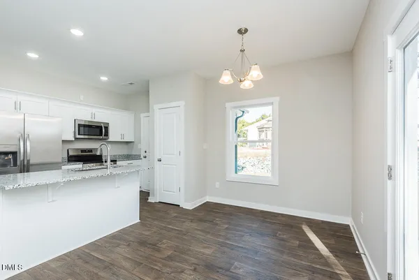 a view of a kitchen with stainless steel appliances granite countertop a sink and microwave