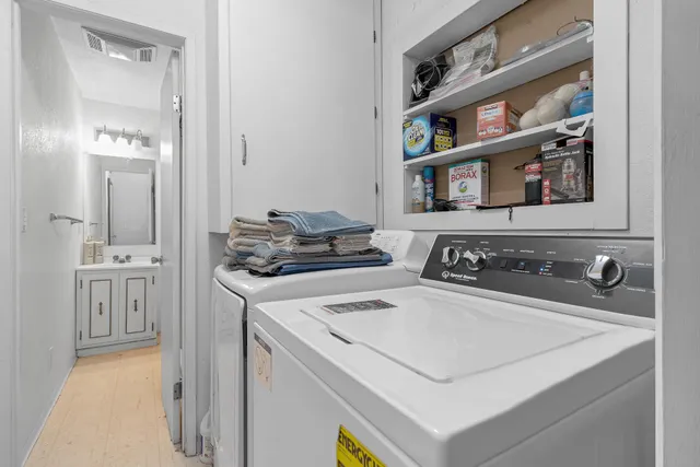 a kitchen with a stove and a shelf with wooden floor