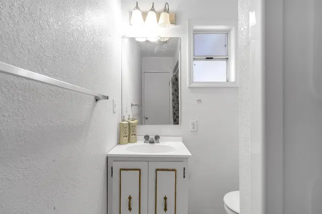 a bathroom with a sink a toilet and mirror