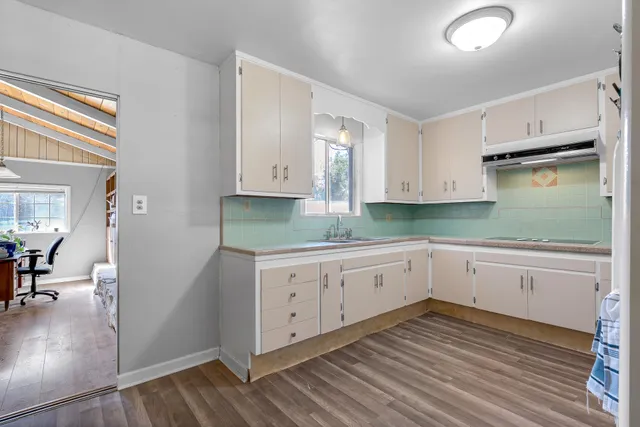 a kitchen with granite countertop white cabinets and white appliances