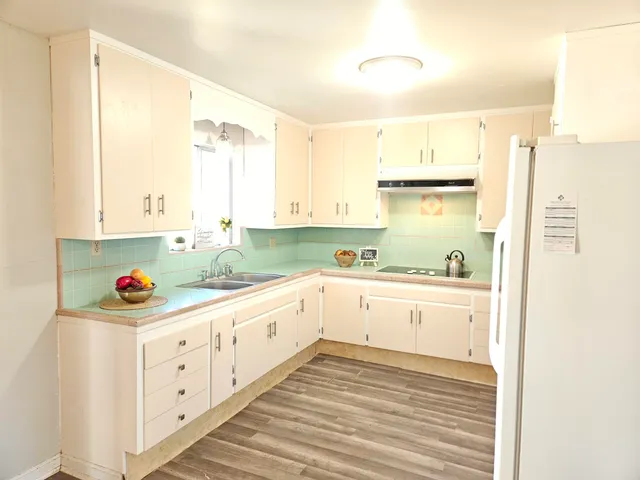 a kitchen with a stove and a shelf with wooden floor