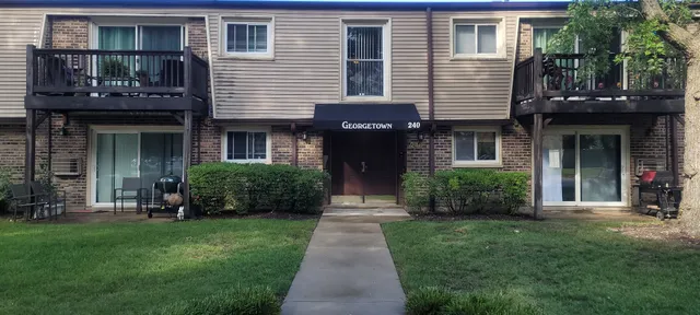 a front view of a house with a garden and plants