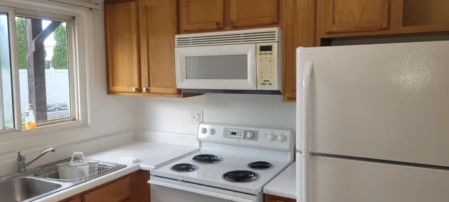 a kitchen with a stove and a white cabinet with a sink