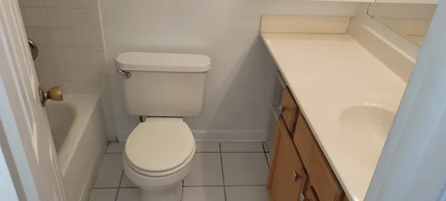 a white toilet sitting next to a shower