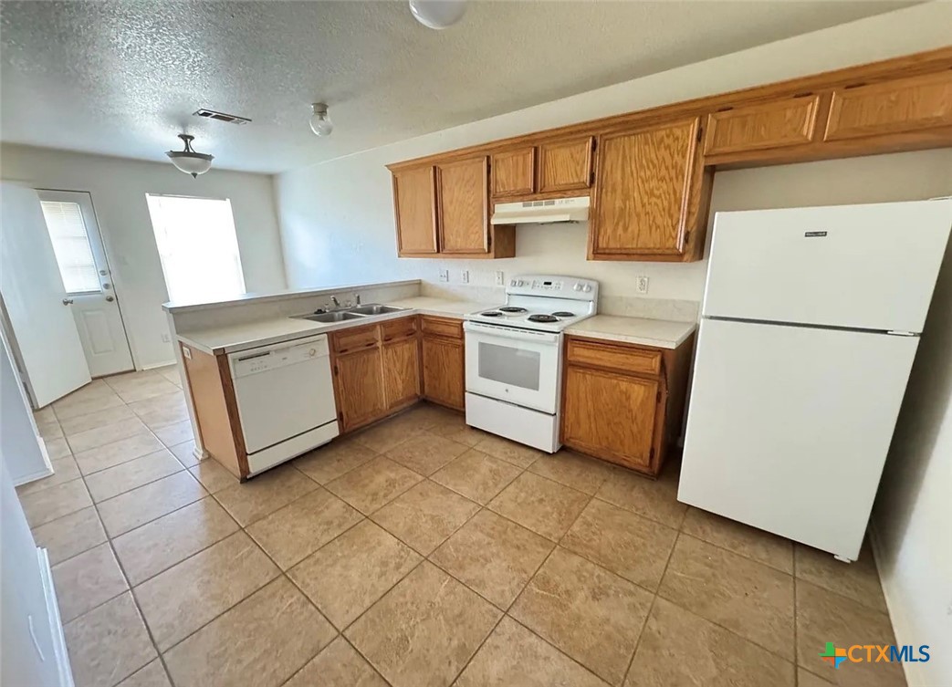 3404 Zephyr Road Killeen, TX 76543 - Photo 6 of 10 a kitchen with stainless steel appliances granite countertop a stove a sink and a refrigerator