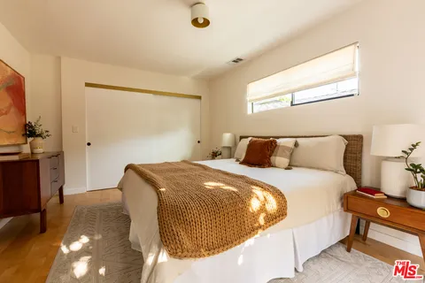 a bedroom with a bed and wooden floor